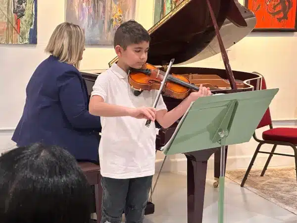 kid learning violin at orchestra music academy